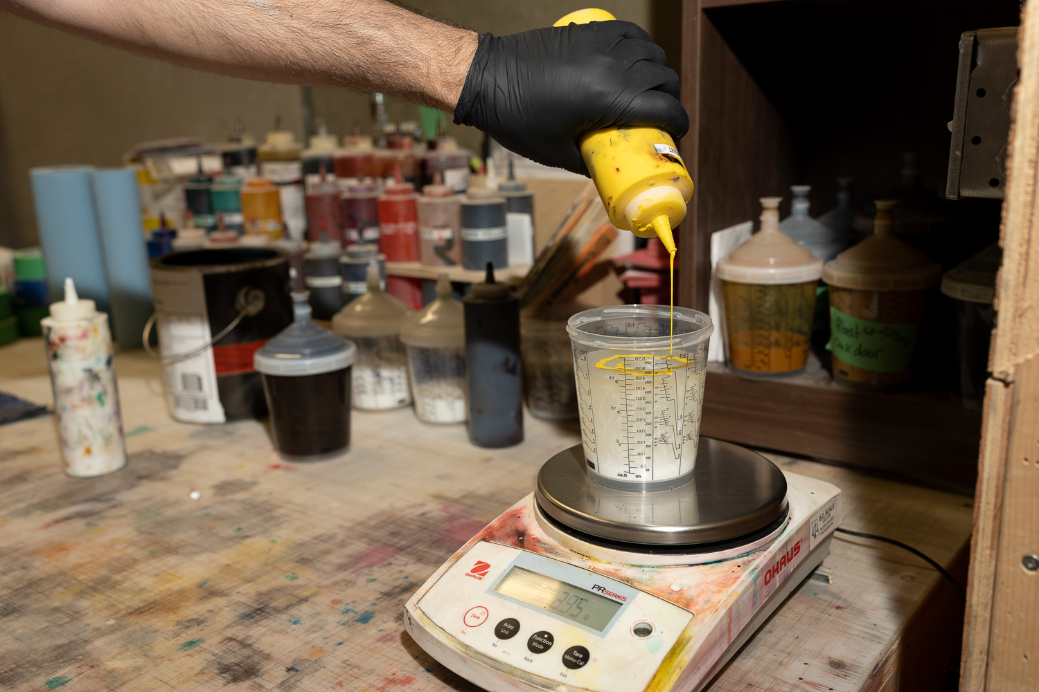 A PPCR cabinet-shop technician mixes a custom finish on a digital scale