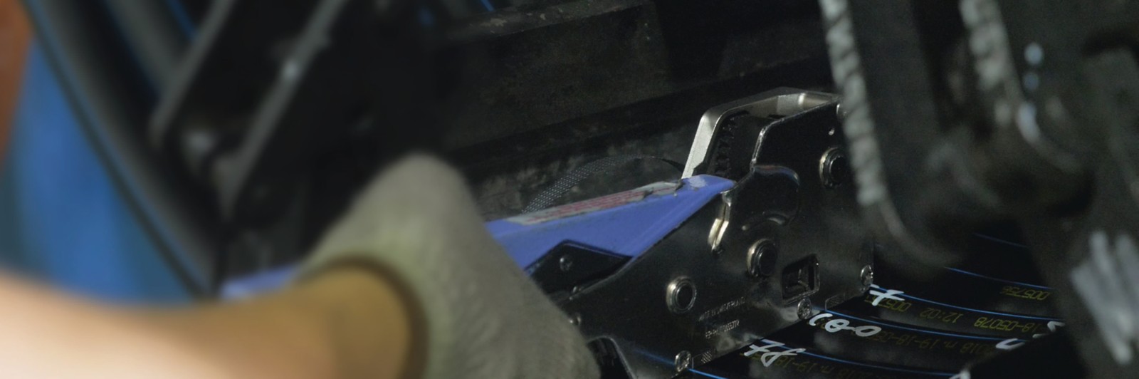 Close view of a gloved hand and a tool working on a component, published in Plex’s Moldtech case study