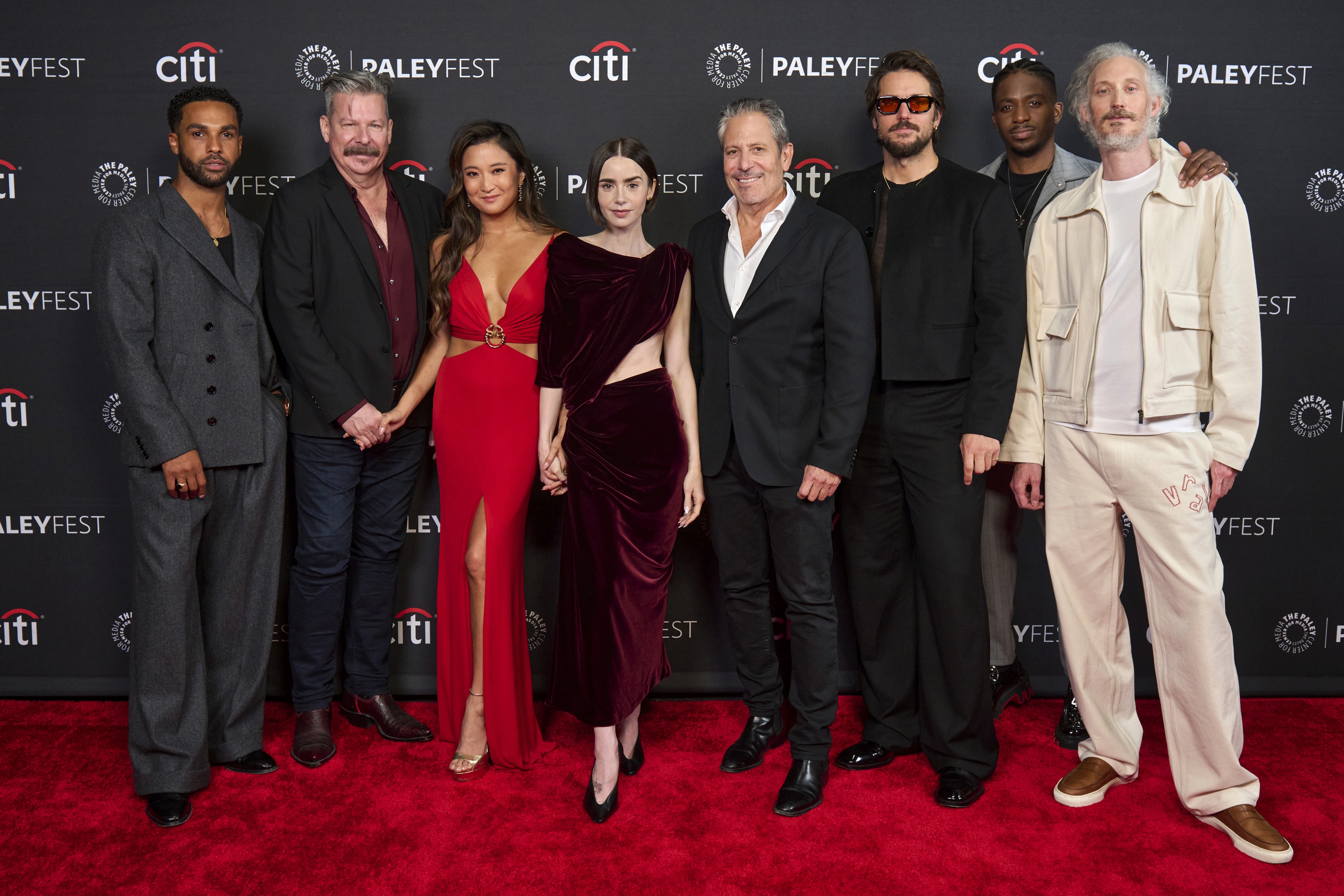 Cast members posing together on a red carpet at PaleyFest