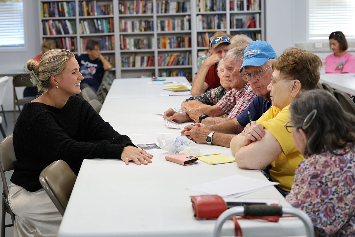 Residents sit around a table with a Point Broadband representative during a streaming education session.