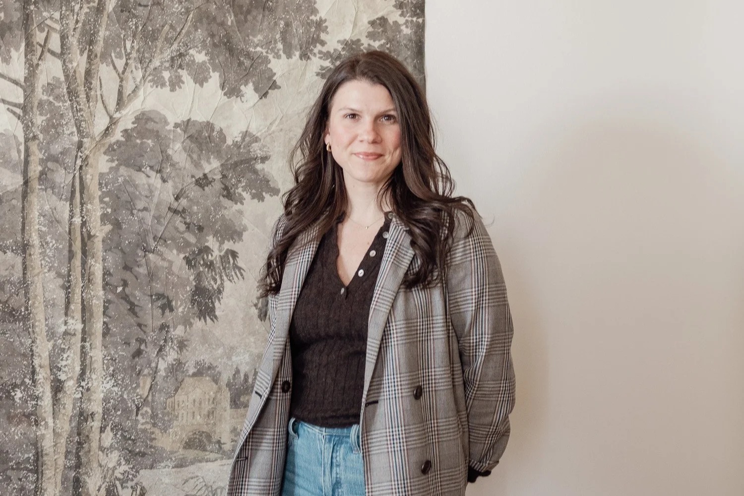 POMME director of marketing Emily Williams standing beside botanical wallpaper