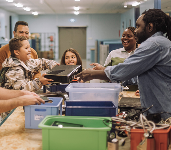 People passing trays and supplies across a table in Popular Bank’s community-service photograph