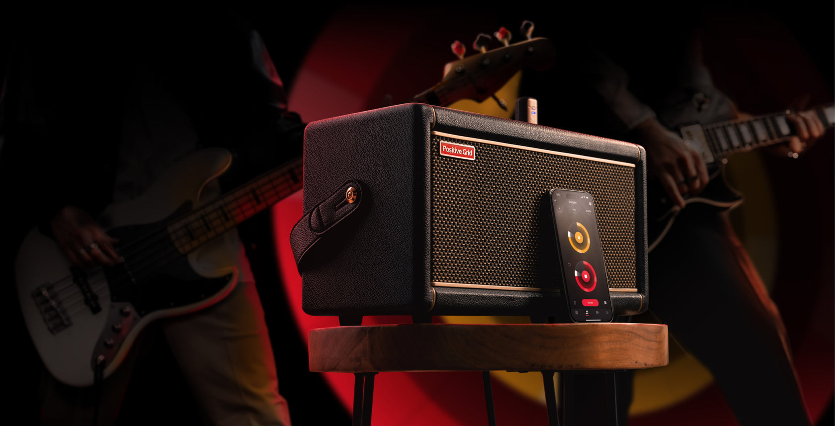 A Positive Grid Spark 2 smart amplifier beside its companion mobile app, with musicians playing in the background