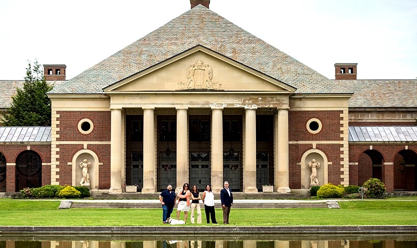 Five members of the Power Communications team standing outside a large historic building