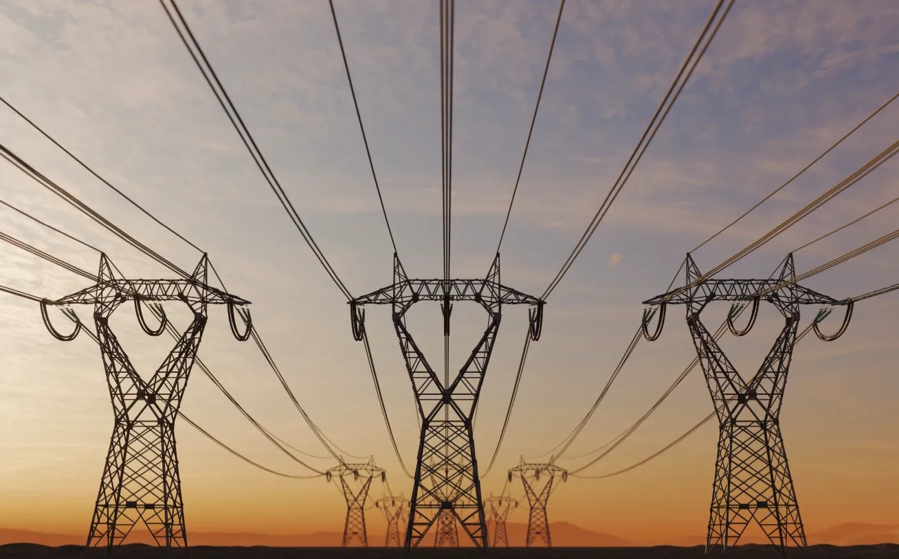 Transmission towers carrying high-voltage power lines across a landscape