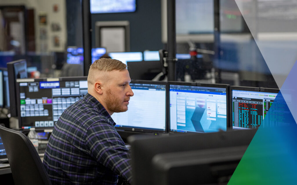 An operator studies several monitors in a PPL control room