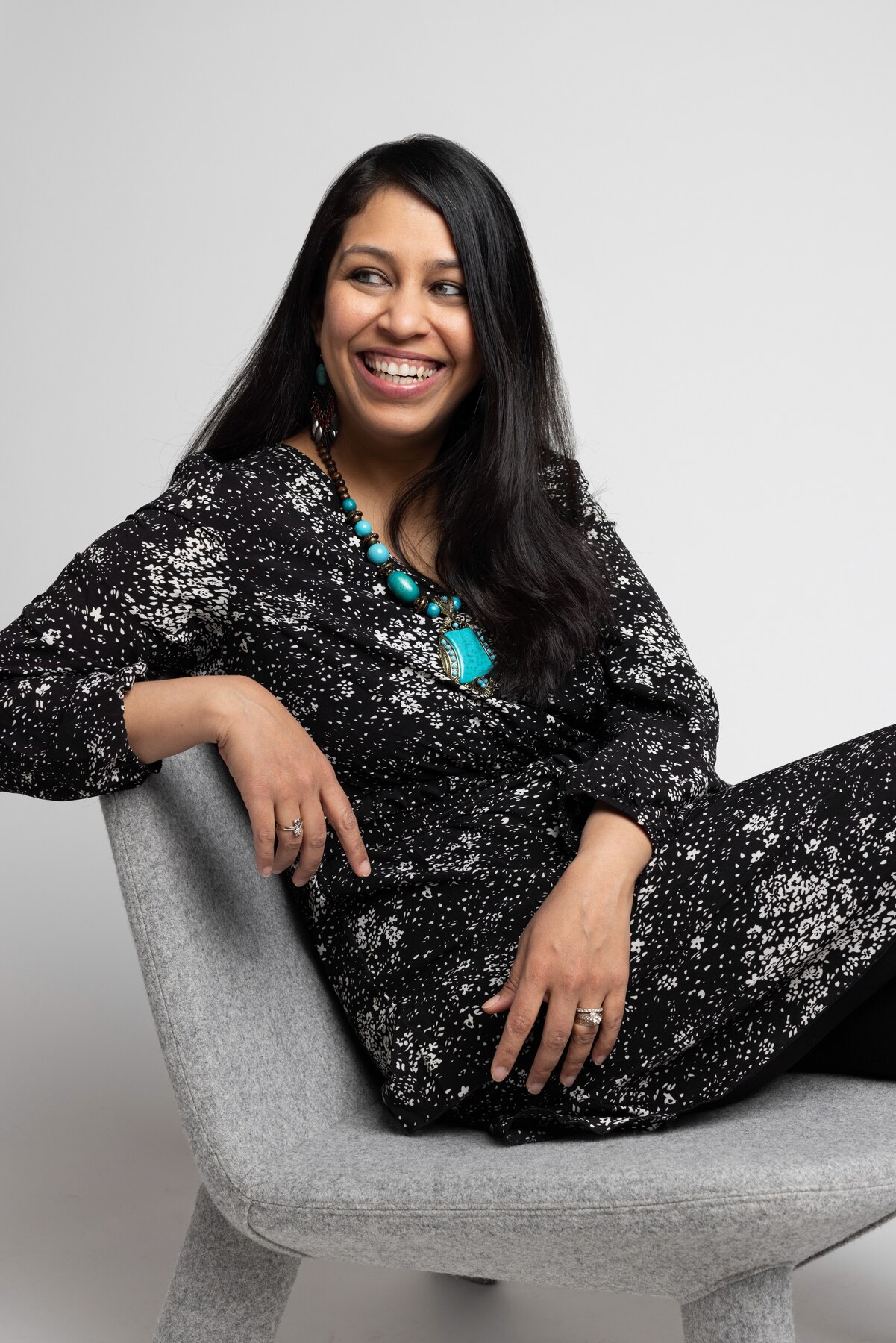 Prachi Gore seated and smiling during an editorial portrait session