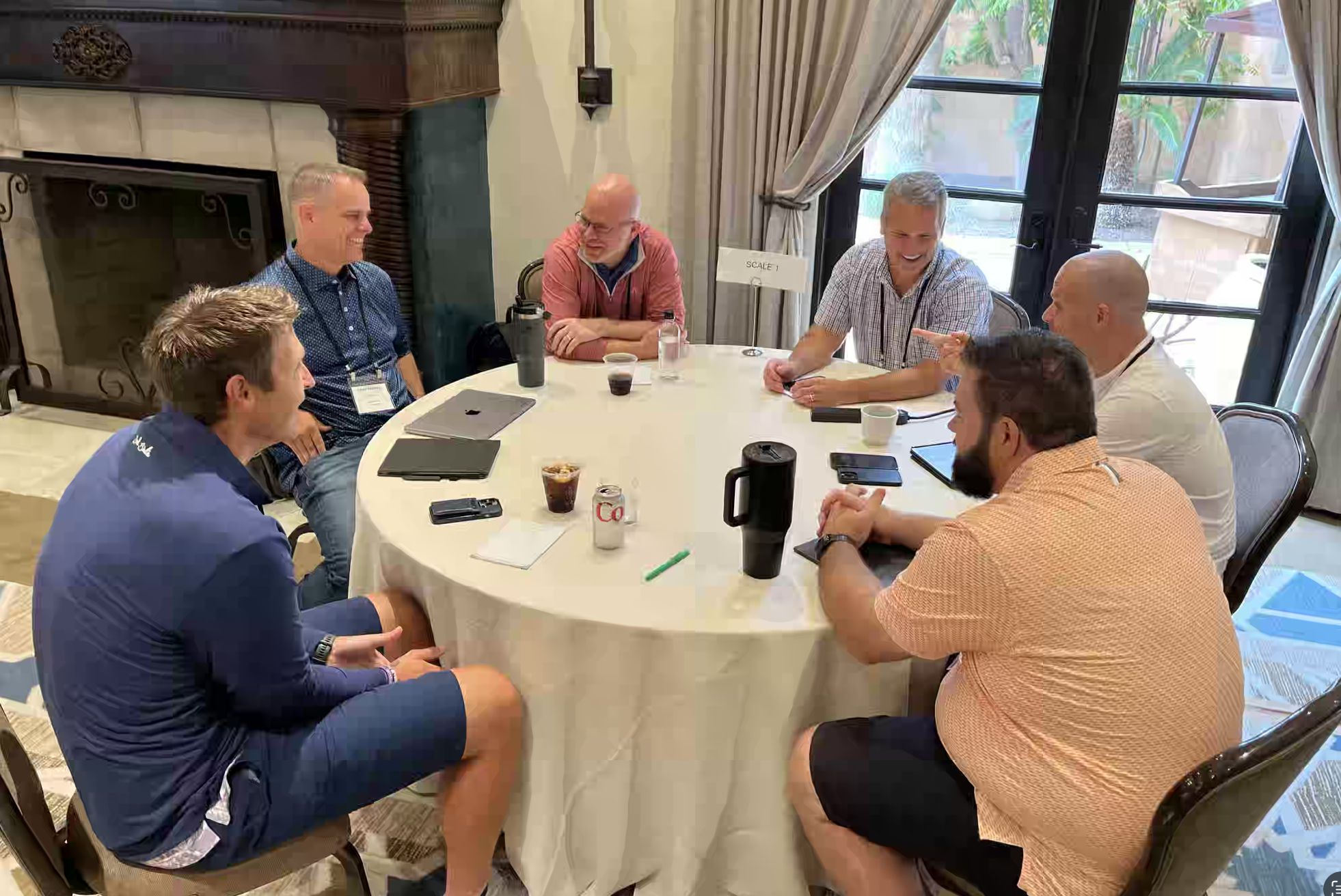 Practical Founders Summit participants discussing business around a table