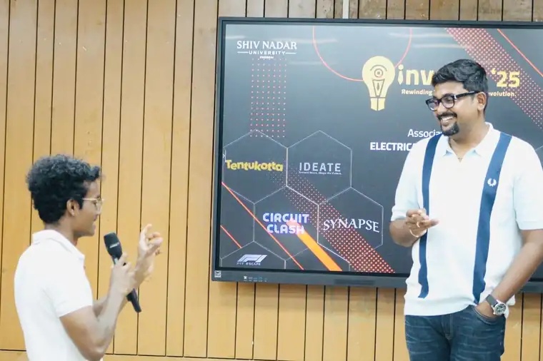 Prady speaking into a microphone on stage