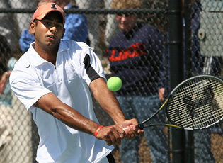 Pramod Dabir playing a two-handed backhand for Illinois, wearing an orange Illinois cap.