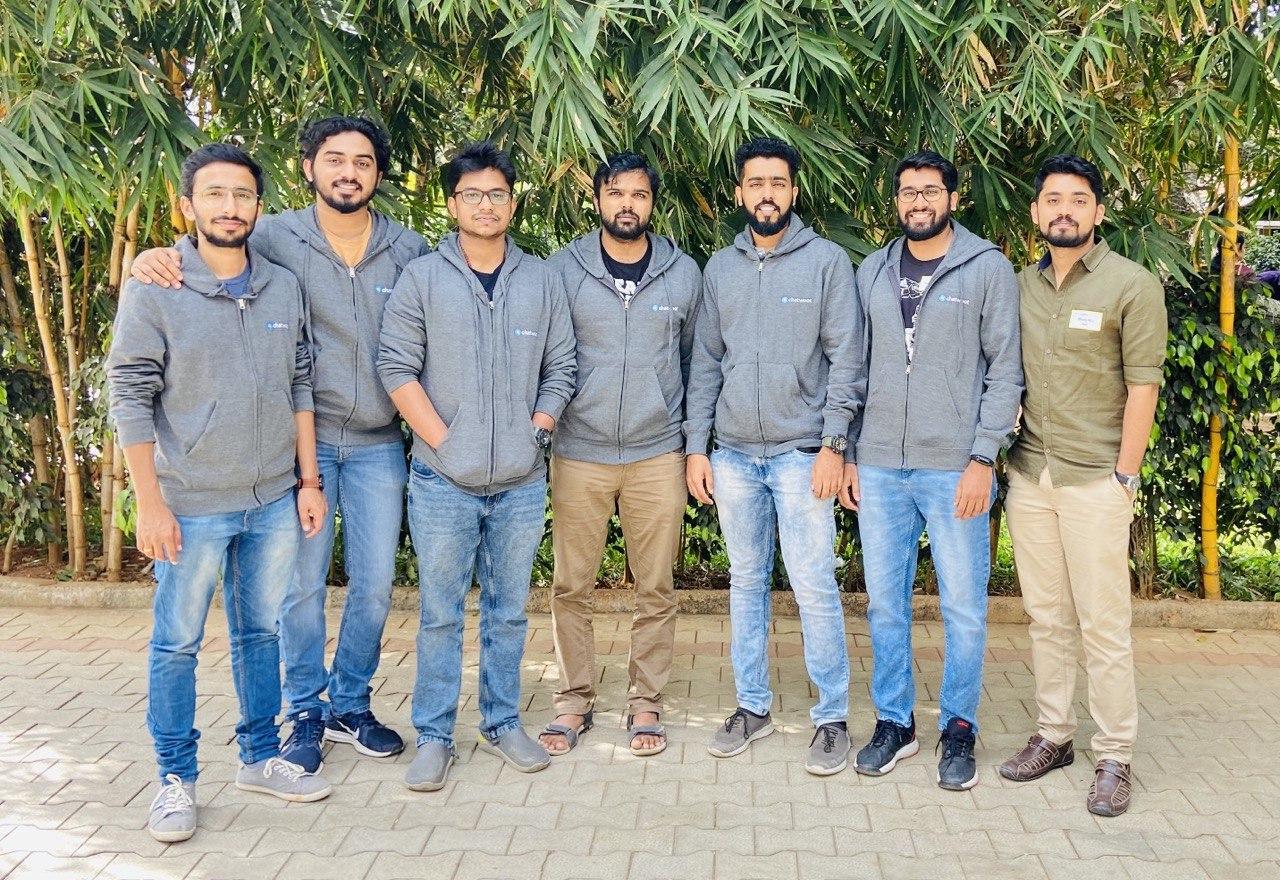 The Chatwoot team standing together outdoors beneath bamboo