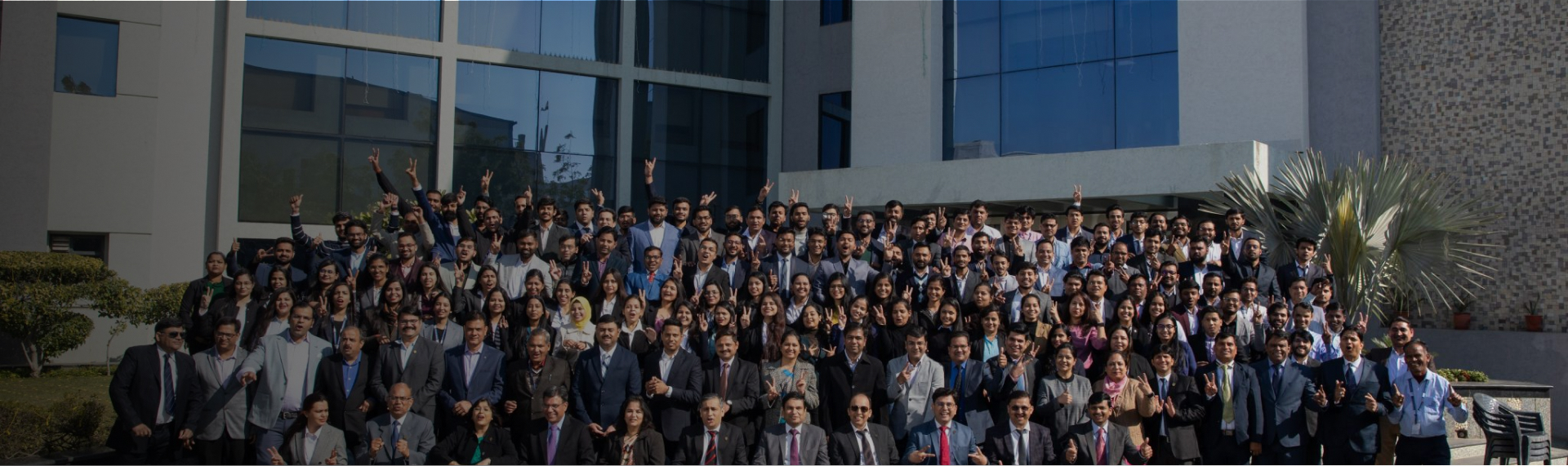 Pratham Software colleagues gathered outside a glass-fronted office building