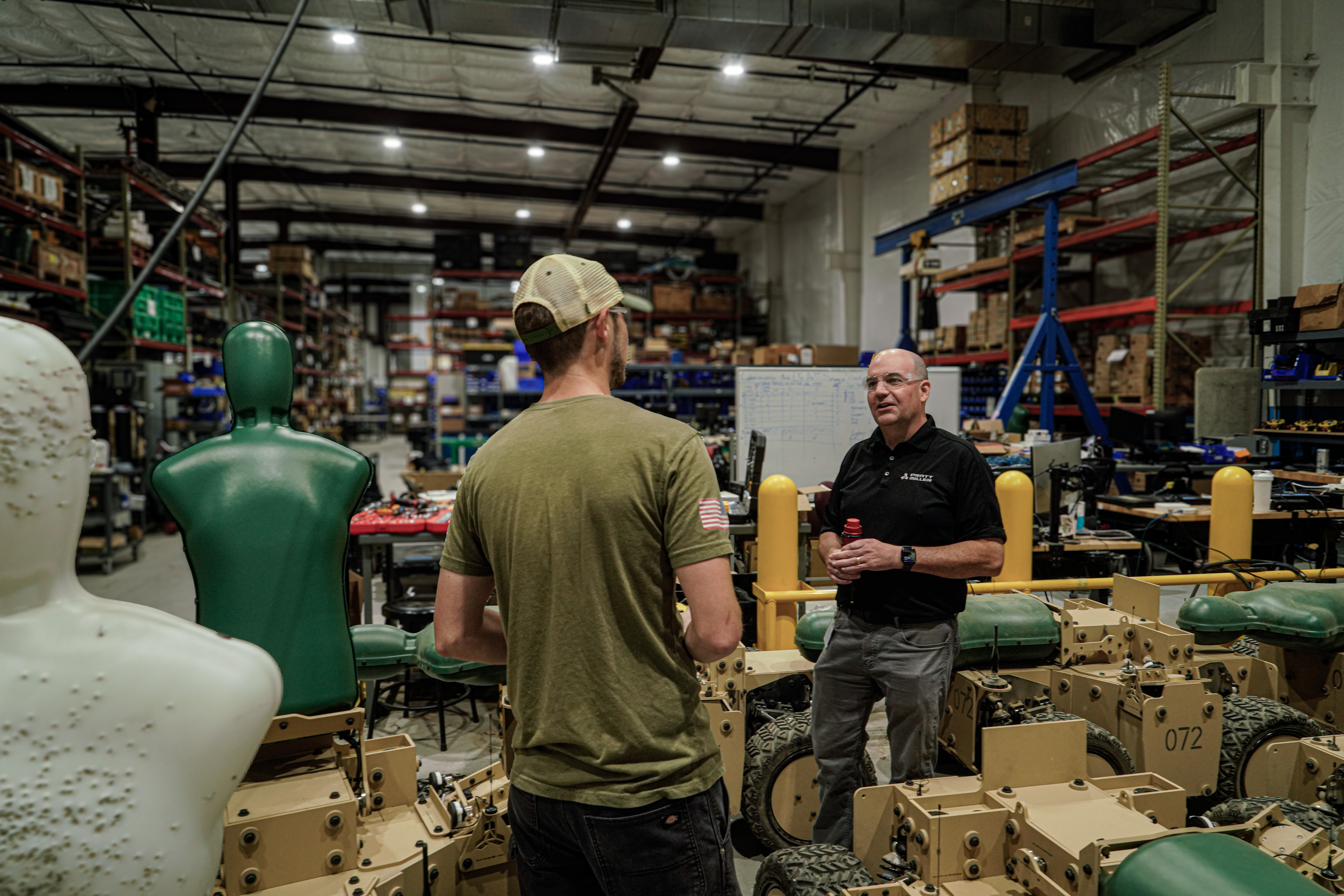 Kris Houghton and Zach Smith reviewing infantry training target robots on the Pratt Miller shop floor