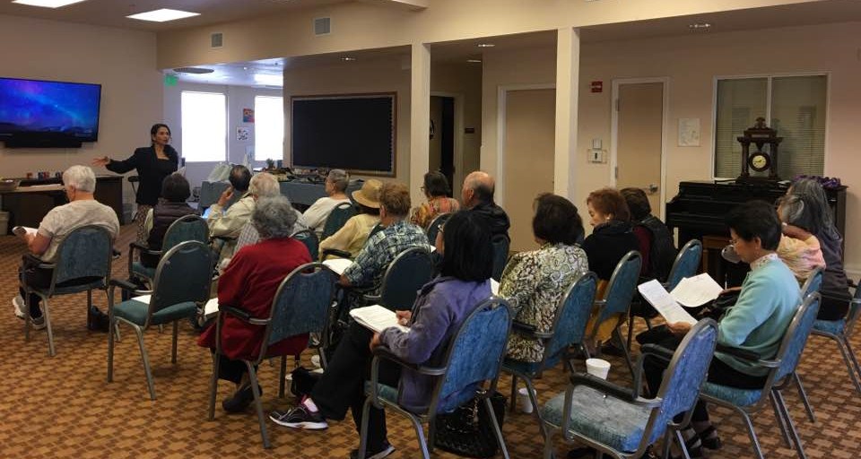 Praveena Kumar speaking to a seated audience in a community room