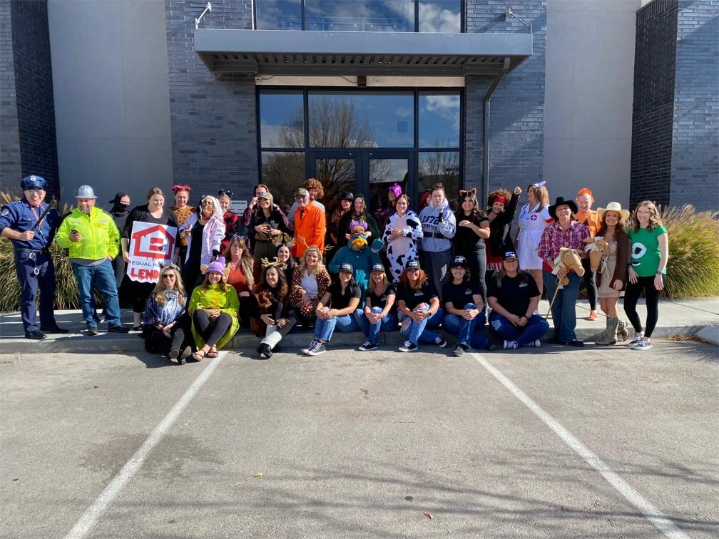 A costumed group in PMR's company gallery, including a person wearing an Equal Housing Lender sign