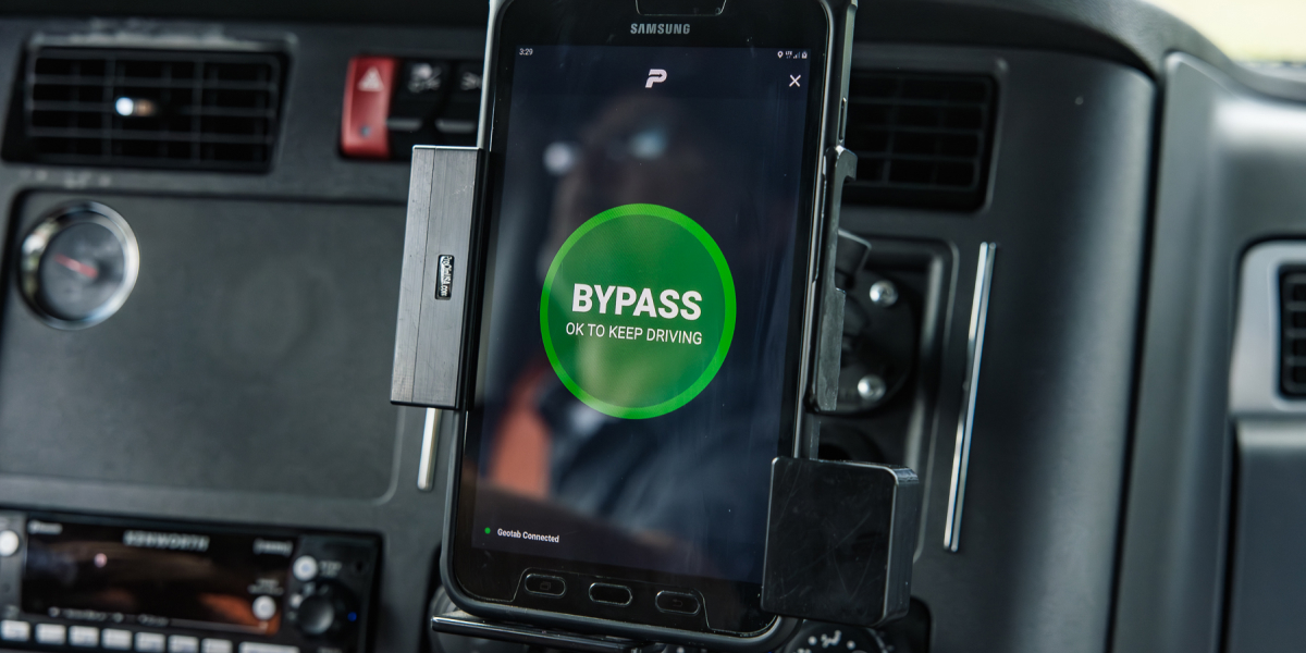 The PrePass mobile app showing a green bypass message inside a truck cab