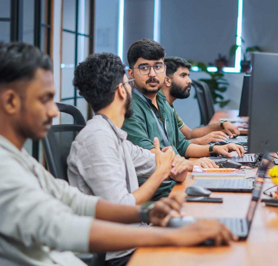 Members of the Prevalent AI team working together at desktop computers