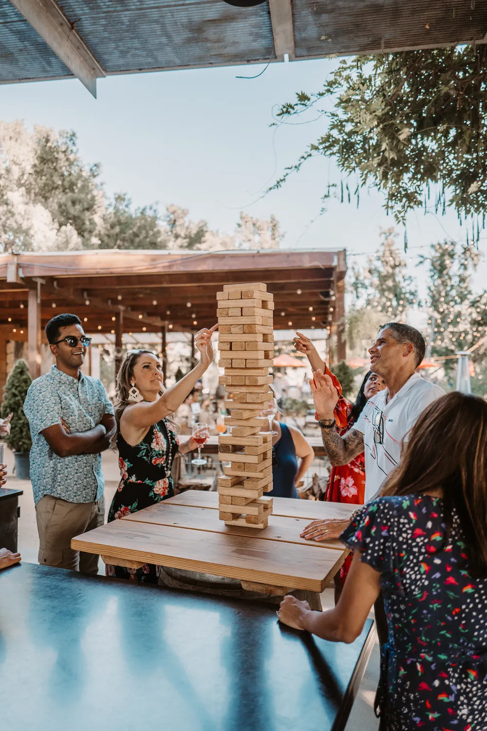 A group playing a large wooden stacking game in a photograph published on Prezent’s About page