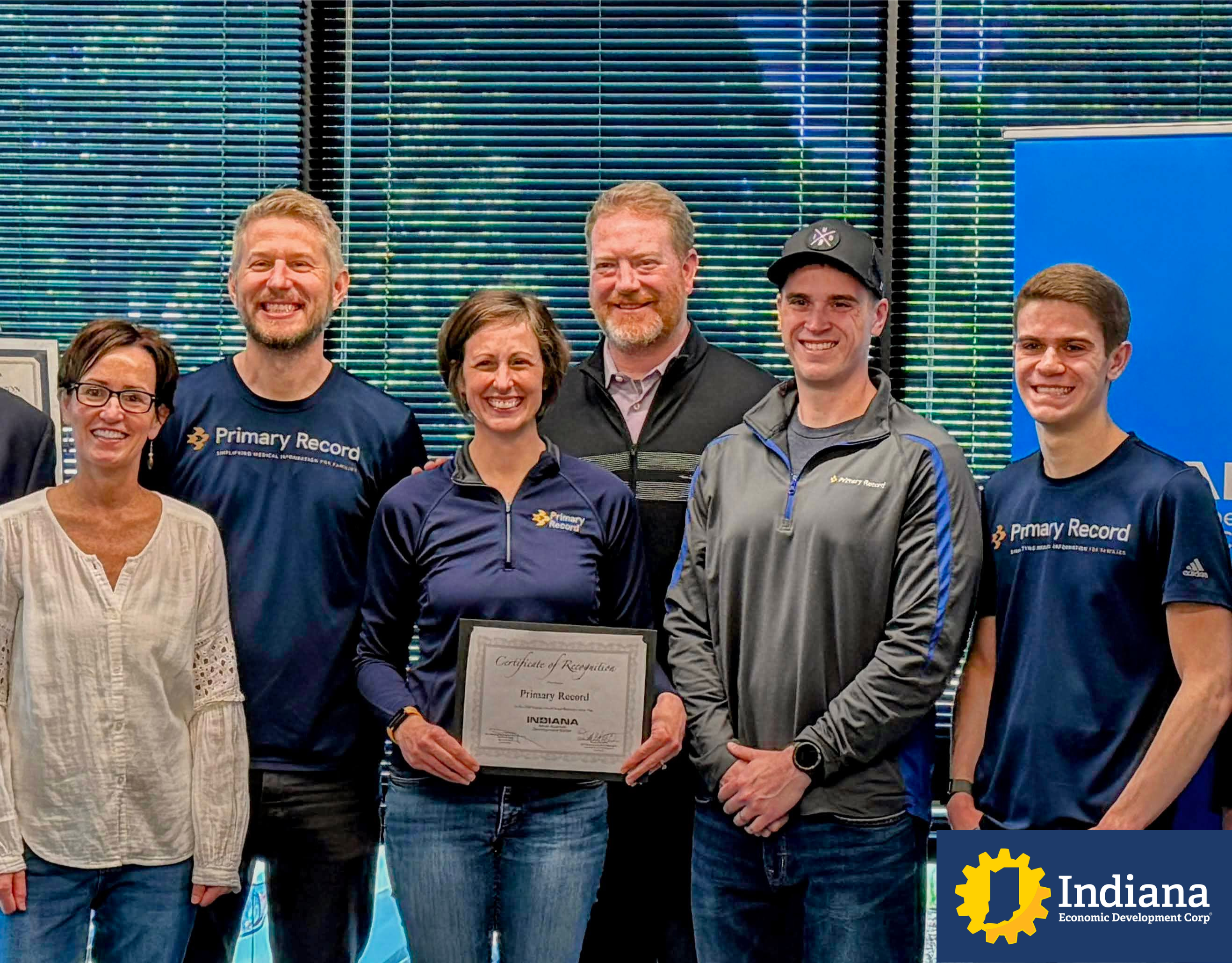 Primary Record team members holding an Indiana recognition certificate