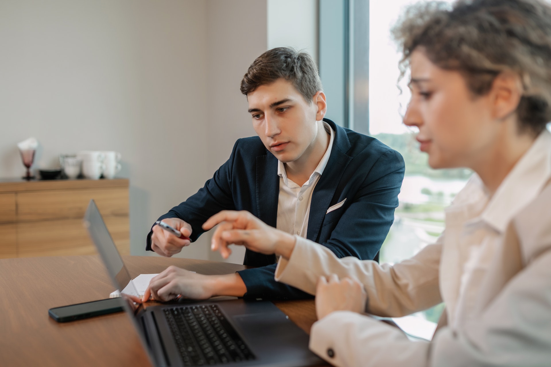 Two people reviewing information on a laptop in a promotional photograph used by Primrose
