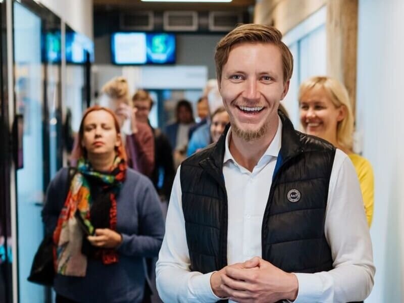 Printify co-founder James Berdigans smiling in an office corridor