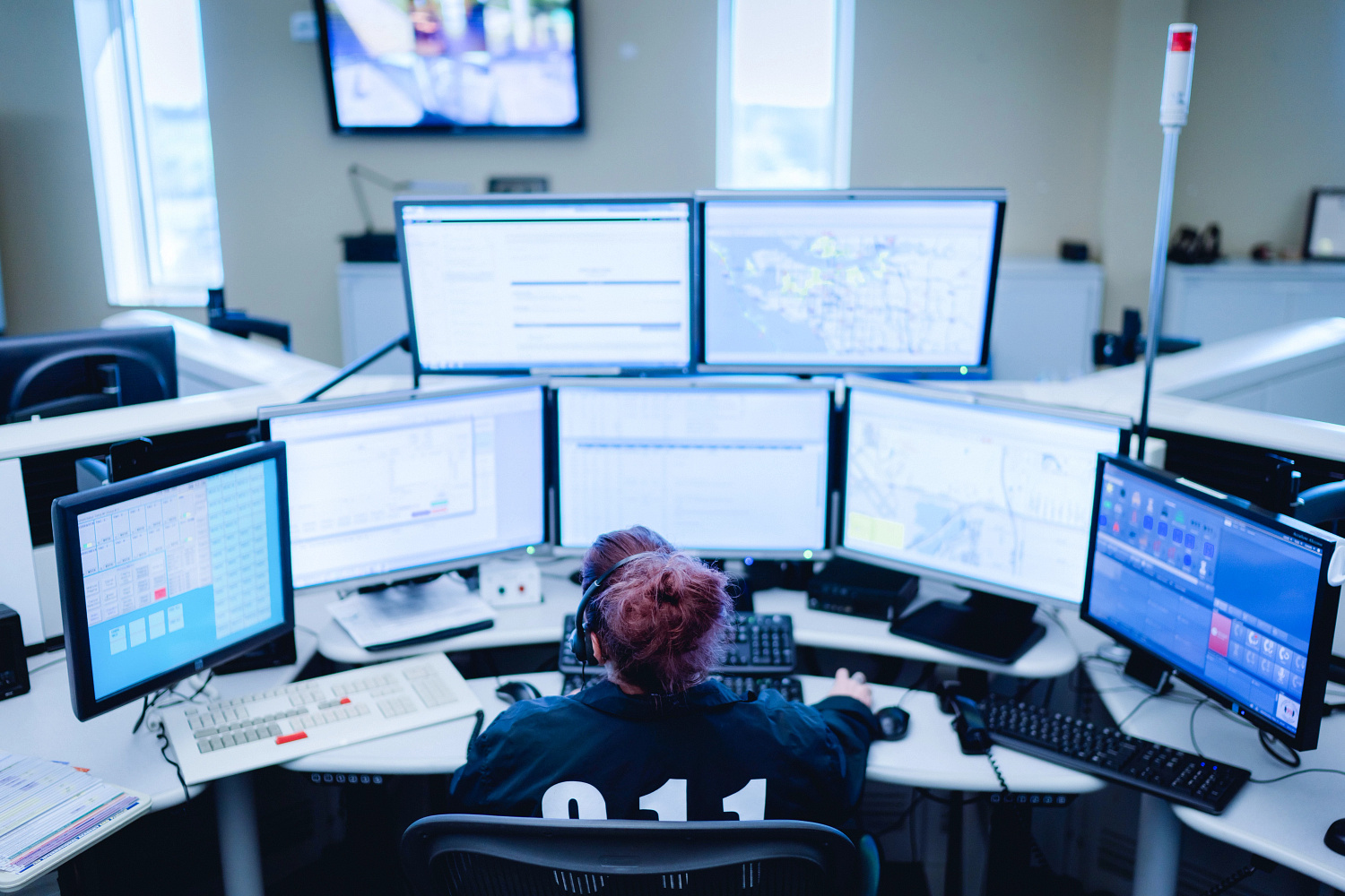 Operators at multi-screen workstations in a dispatch centre, photographed in Manatee