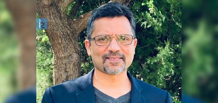 Prithwi Dasgupta outdoors, wearing glasses and a dark blazer