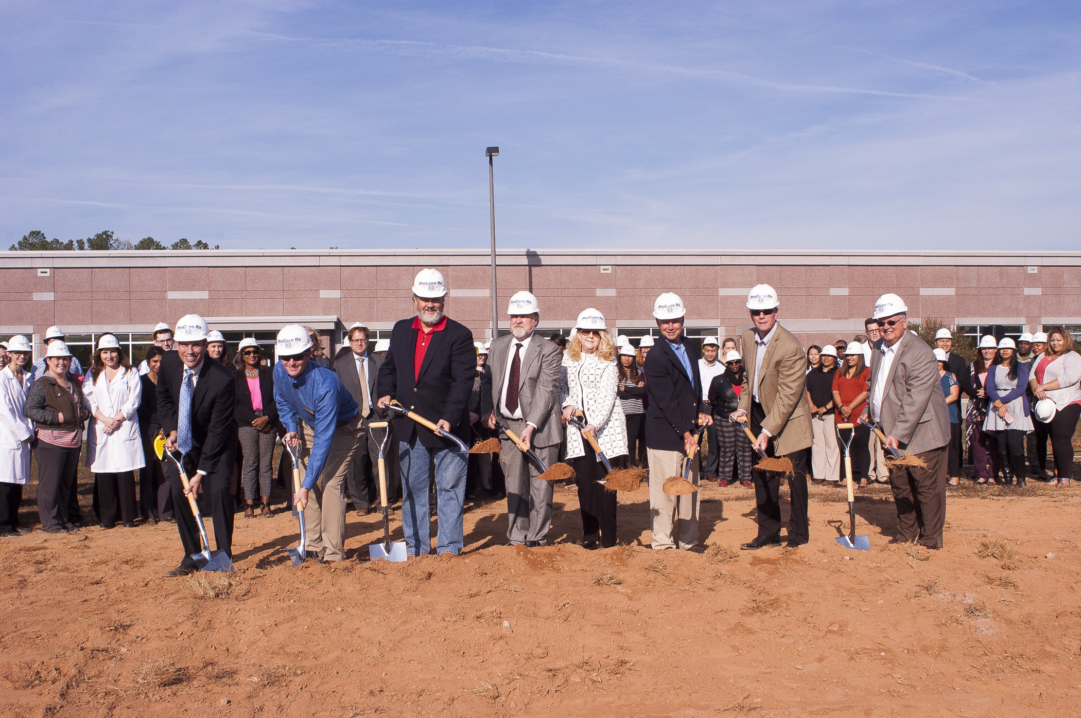 People in ProCare Rx hard hats holding shovels at the company’s expansion groundbreaking