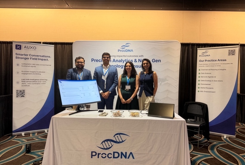 Four ProcDNA team members at a conference booth with an Auxo display
