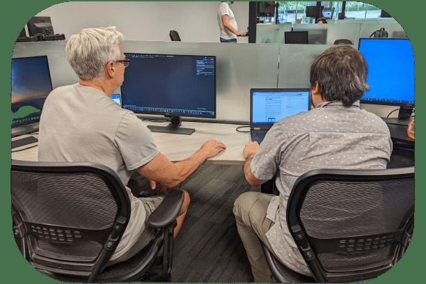 Two Profisee employees collaborating at computer workstations in the company's office