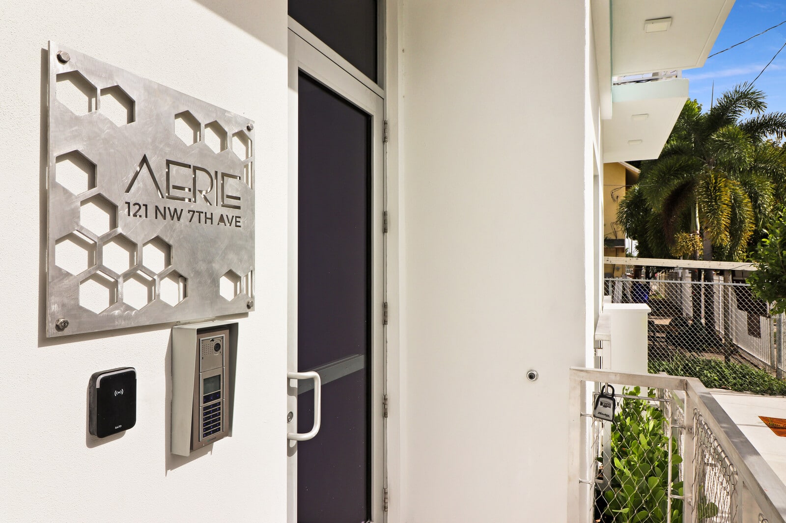 The entrance to AERIE Apartments in Miami, with its metal honeycomb sign and keyless access