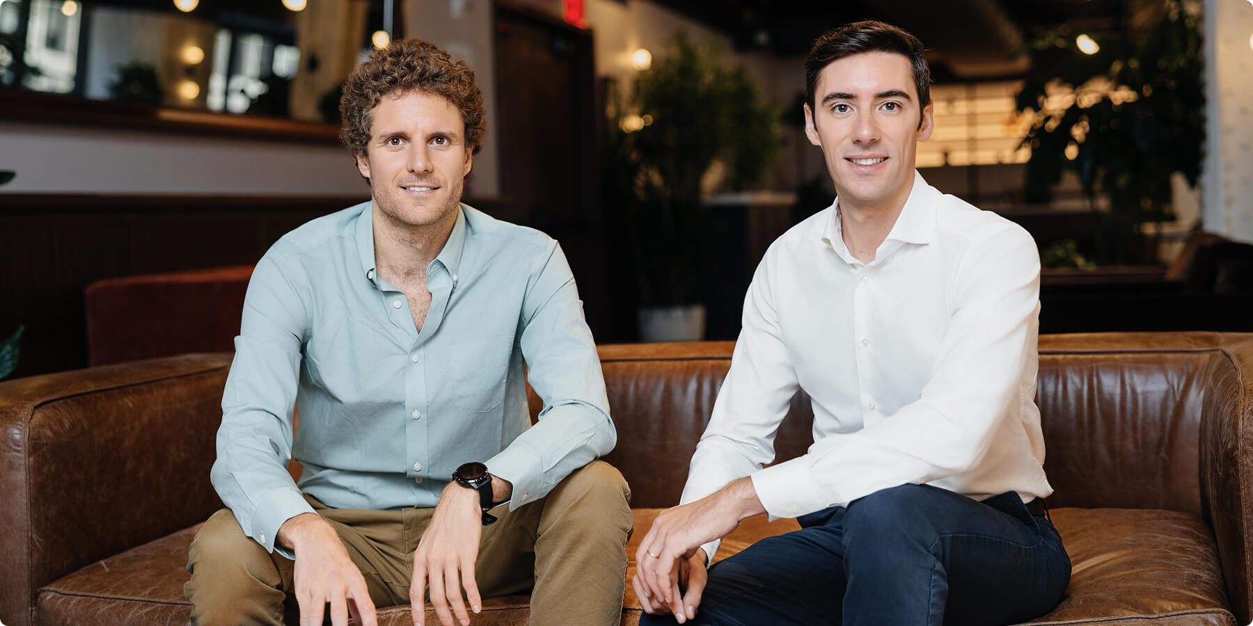 Prosper AI’s two co-founders seated on a leather couch