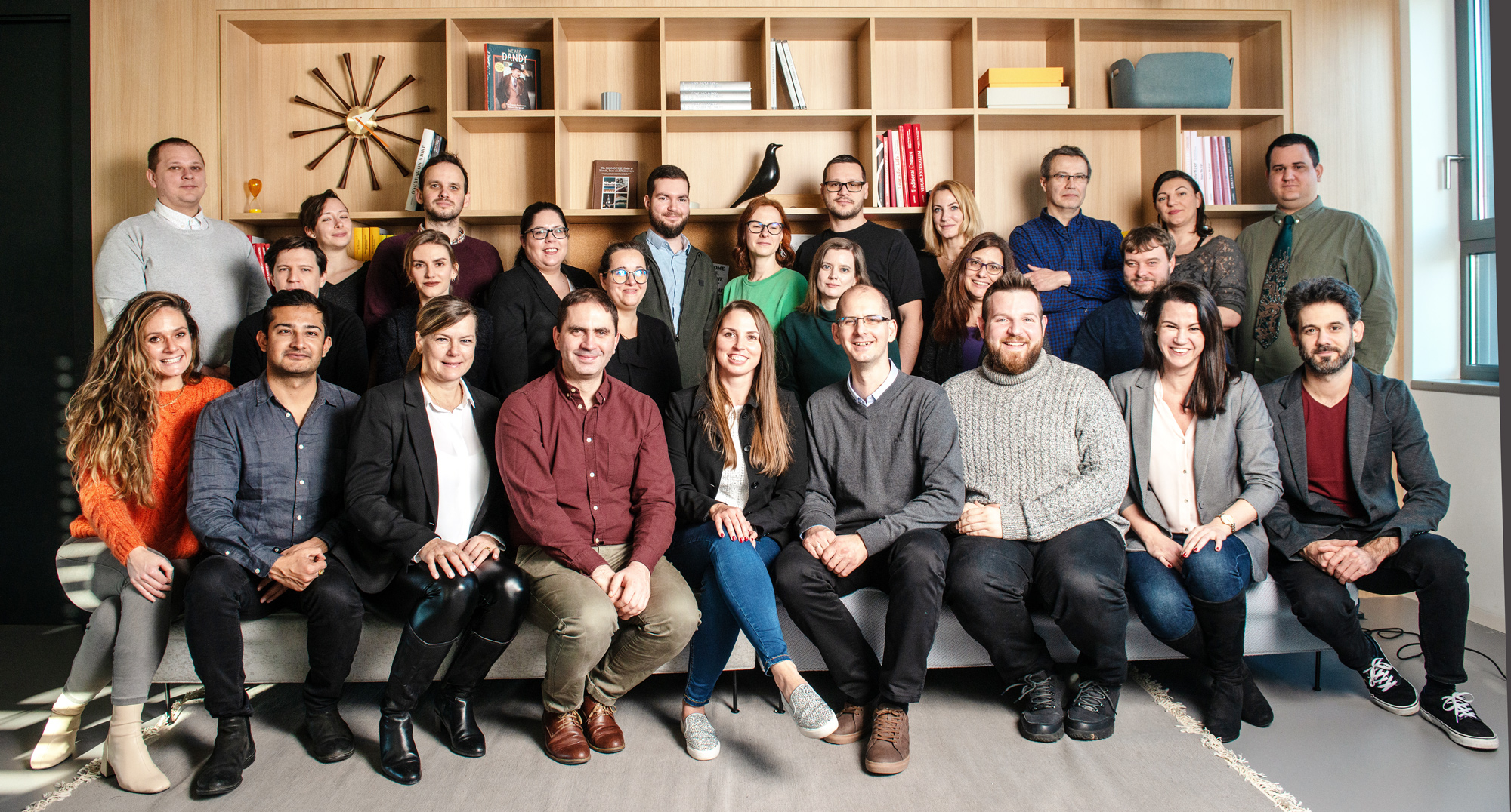 PublishDrive team gathered for a group portrait in front of office bookshelves