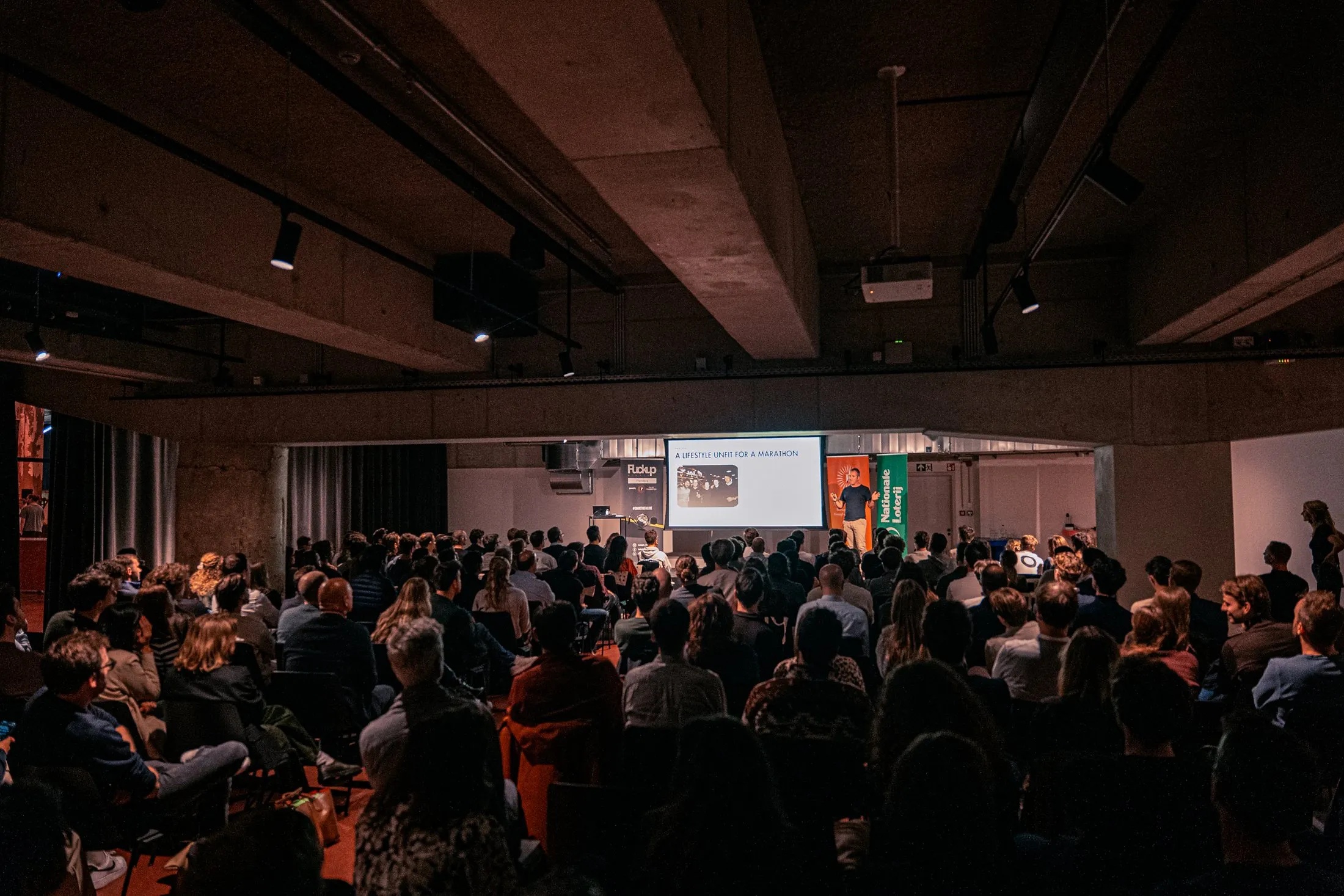 An audience listening to a founder at a Fuckup Nights evening
