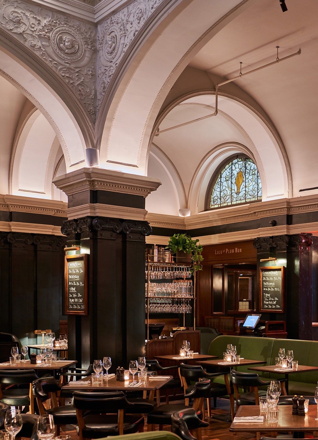Ornate vaulted ceiling and dining tables inside Hawksmoor New York