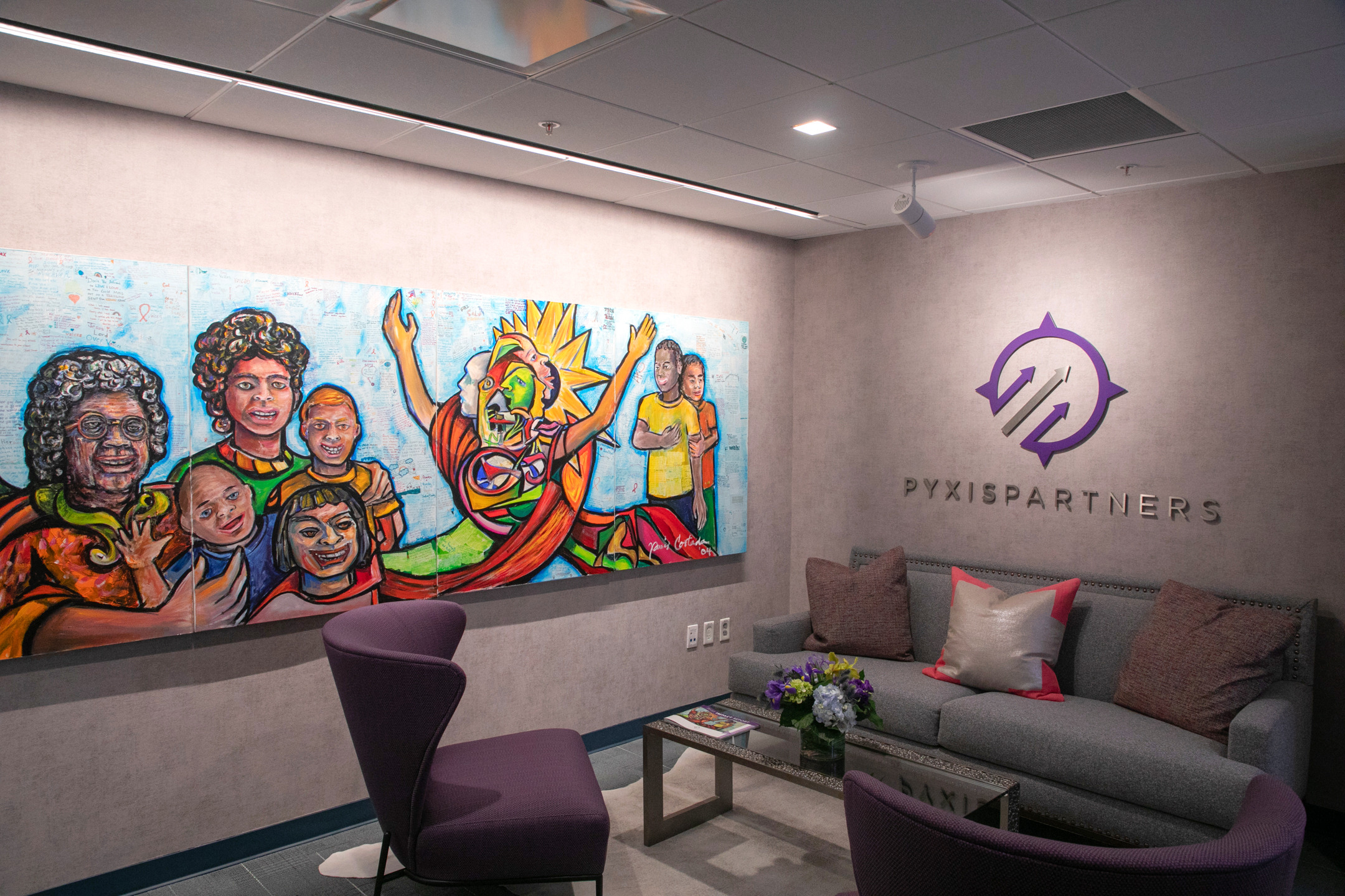 Pyxis Partners' Washington office, with a colorful painting of community figures beside the company mark