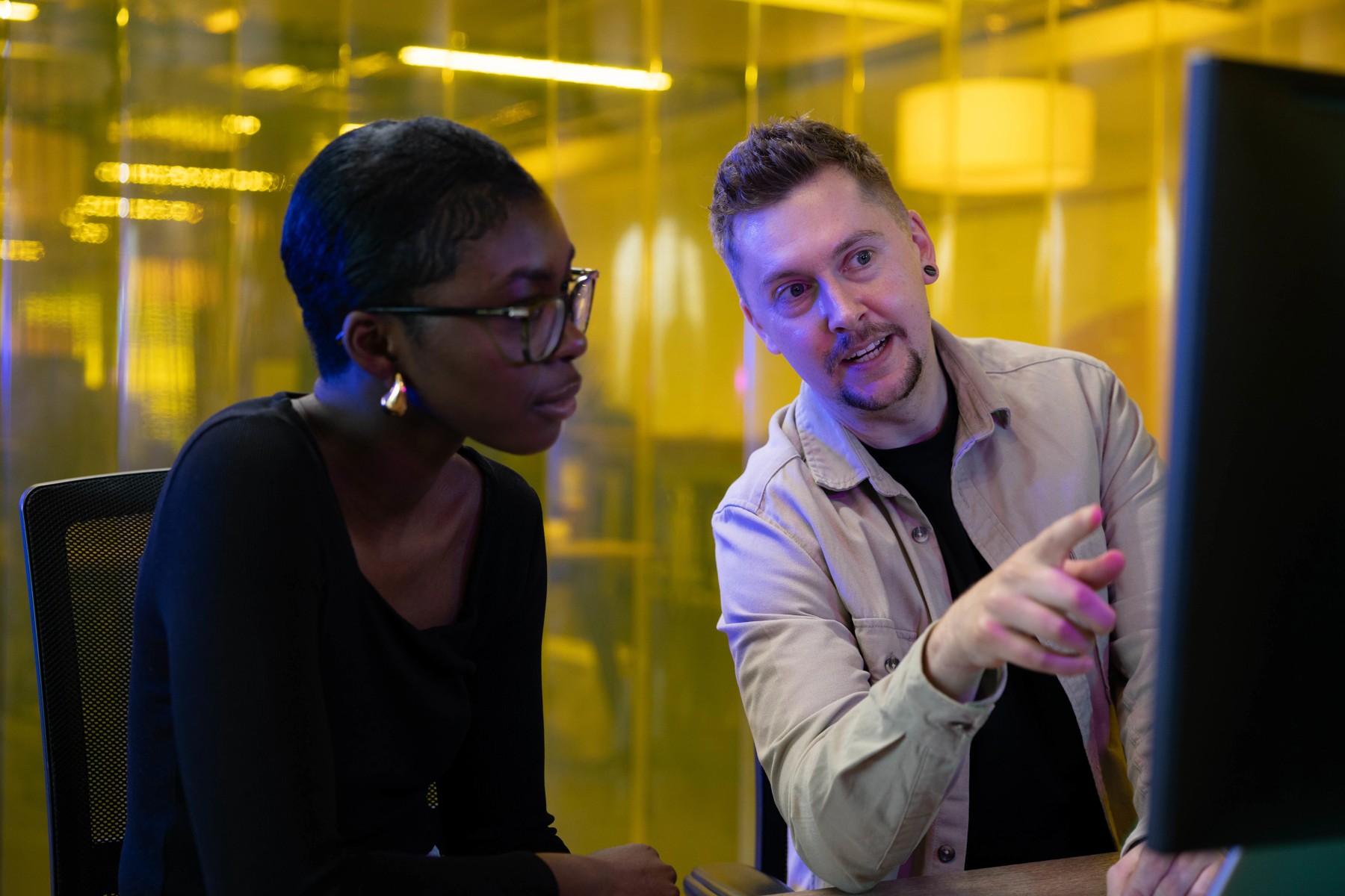 An apprentice and learning coach look at a computer together in QA’s promotional photograph.