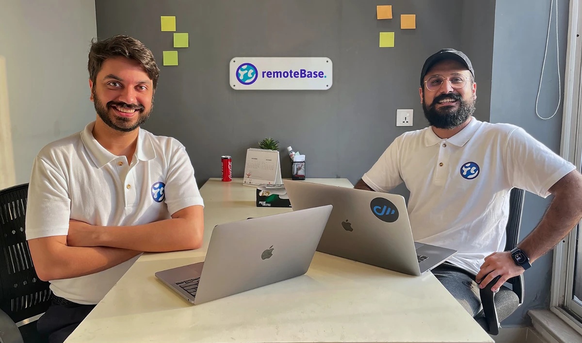 Qasim Asad Salam, left, and Talha Masood seated with laptops at Remotebase in Lahore