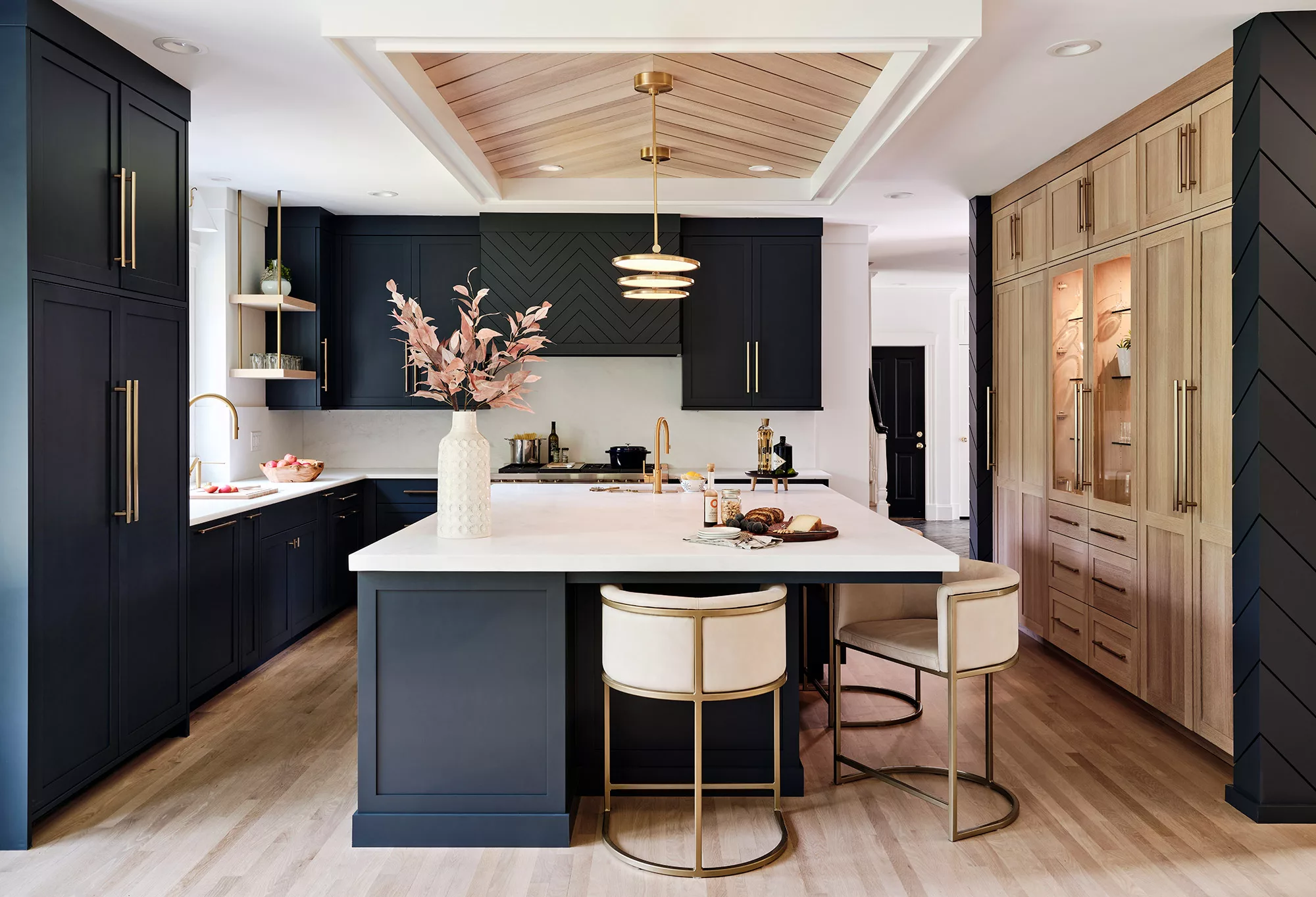 A QCC Vision collection kitchen with dark cabinetry, wood display cabinets and a pale island