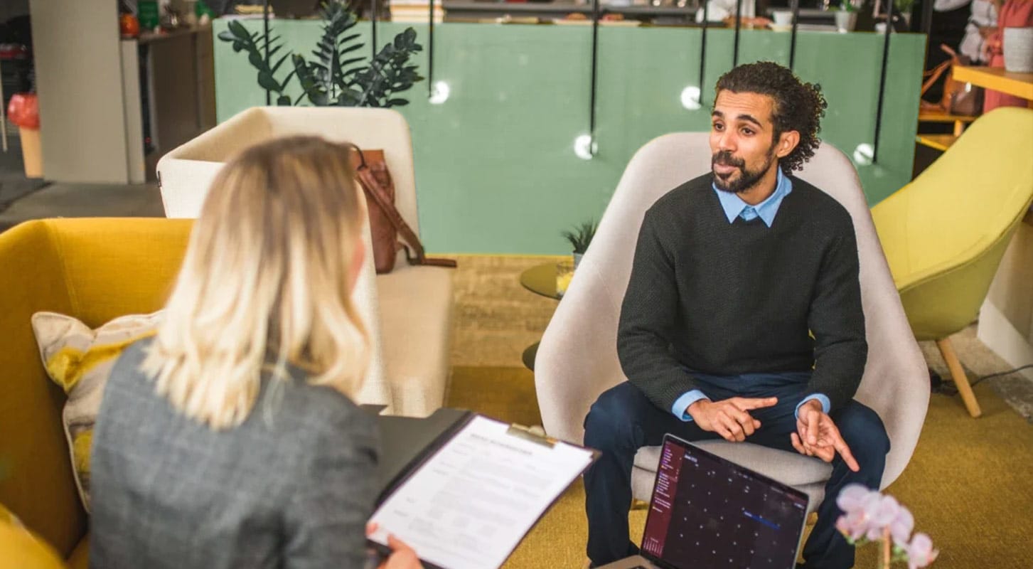 Two Qlik colleagues speaking in a colorful office seating area