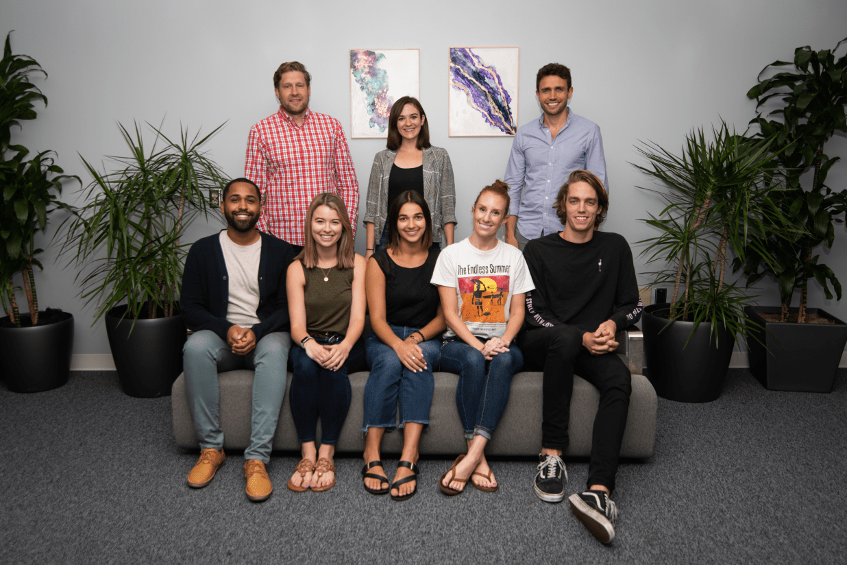 Eight members of the Qualia team seated and standing in an office
