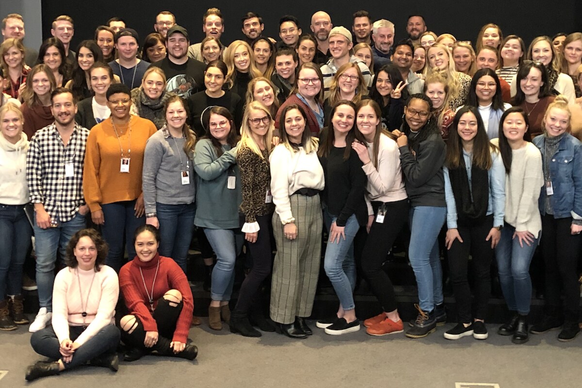 Members of the Qualtrics People Team gathered together in a bright office