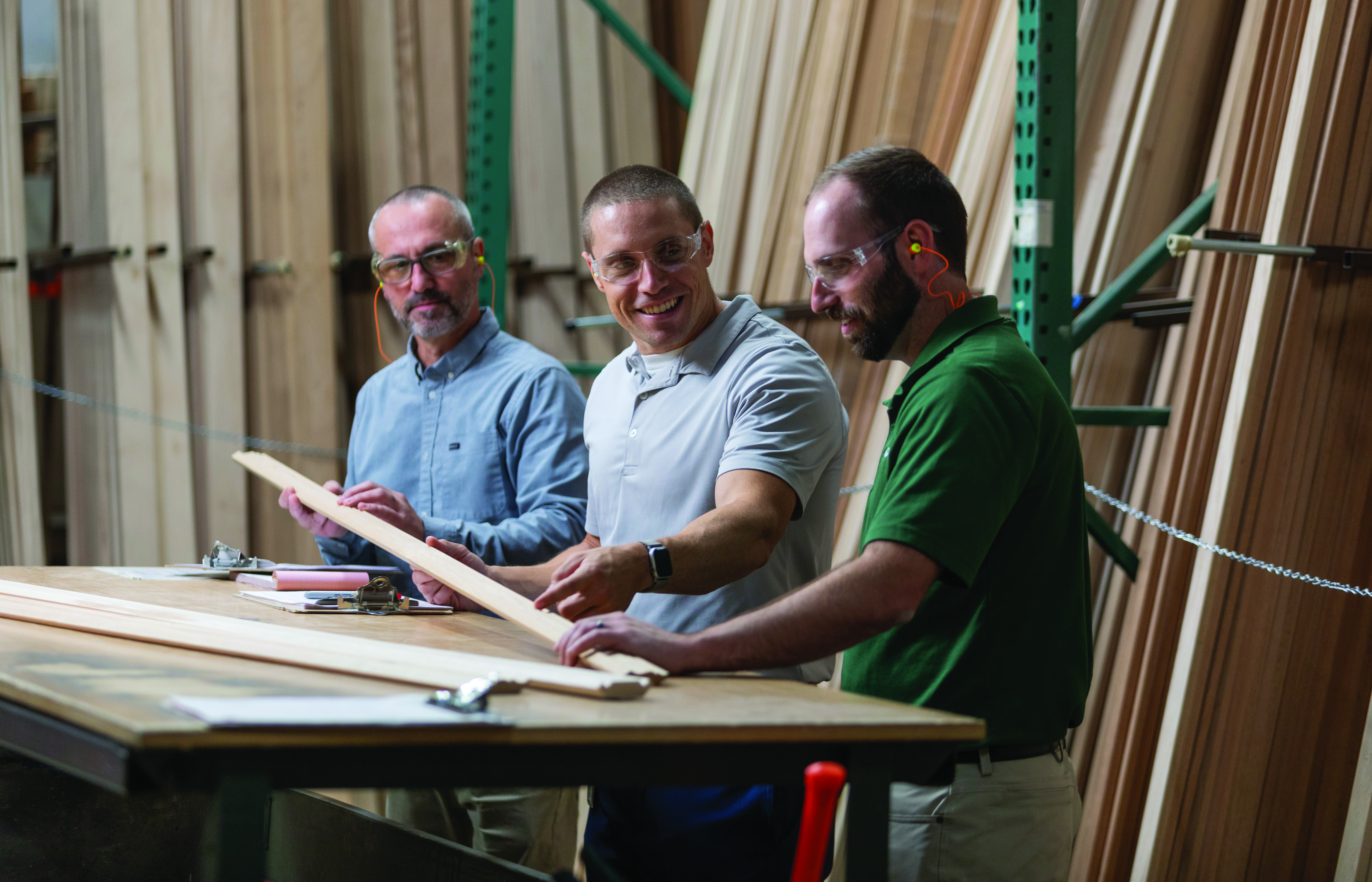 Quanex and Canyon Creek representatives examining a wood component at a worktable