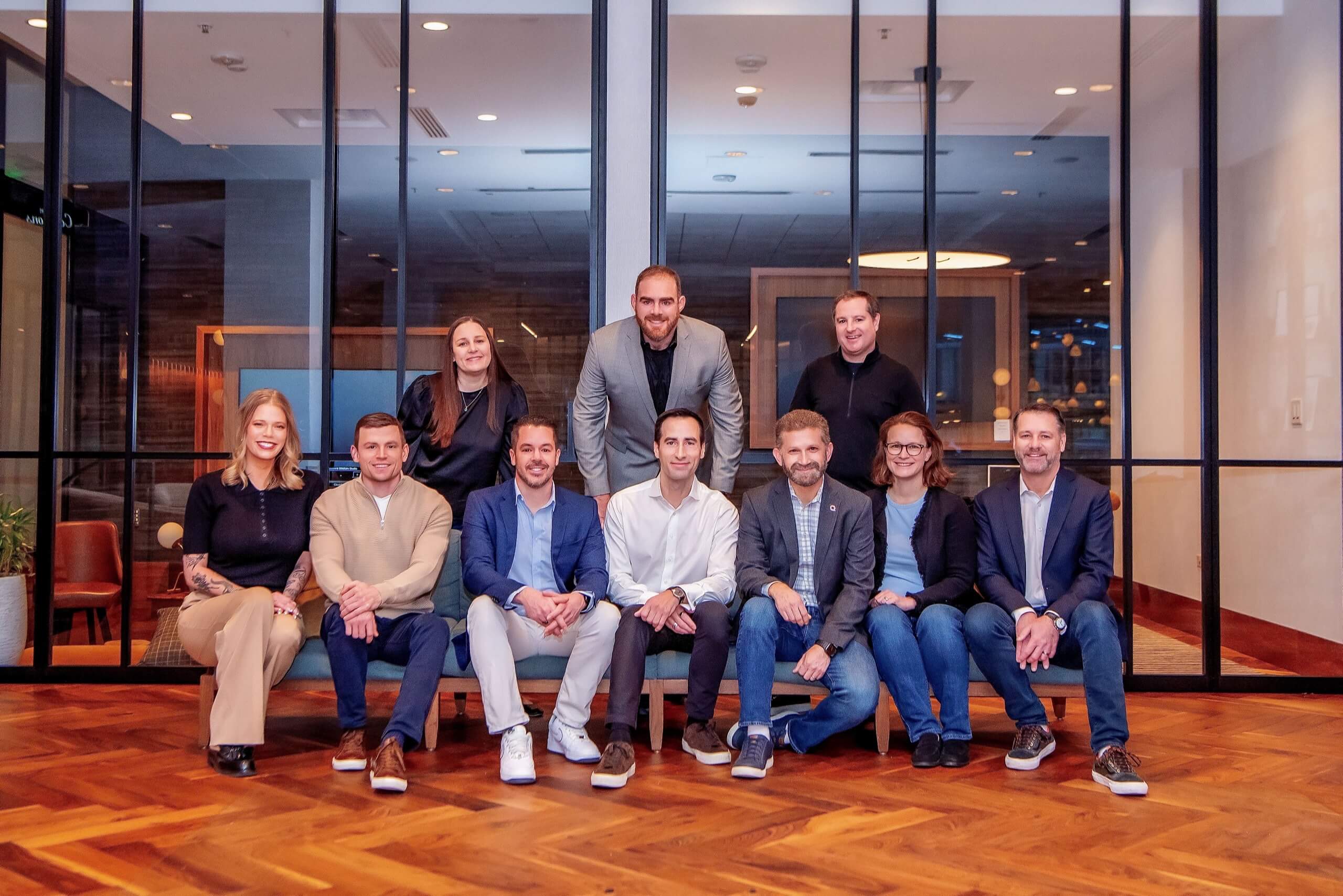 Quantum Metric executive team standing together in a modern office