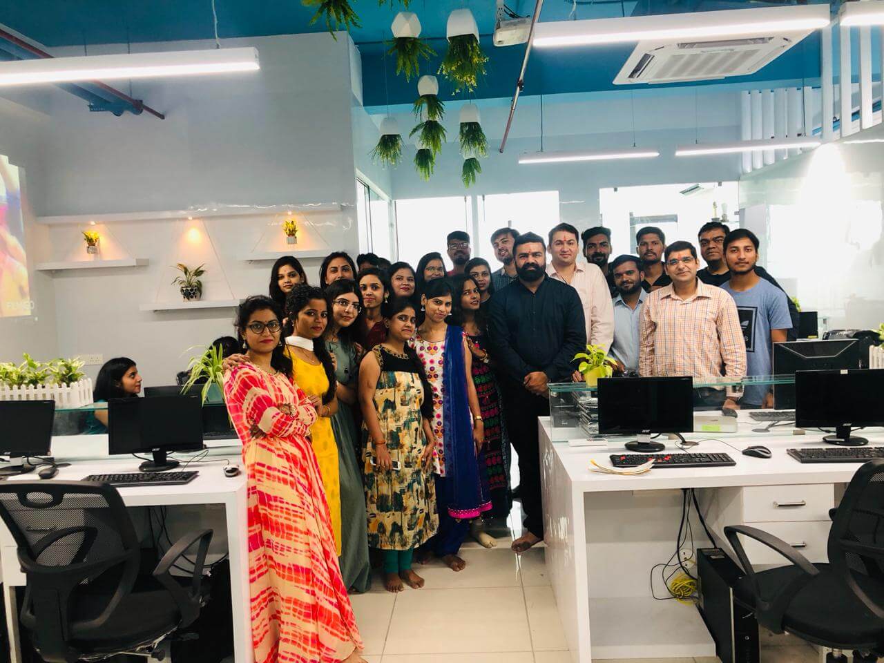 Quest GLT team gathered between desks at an office opening