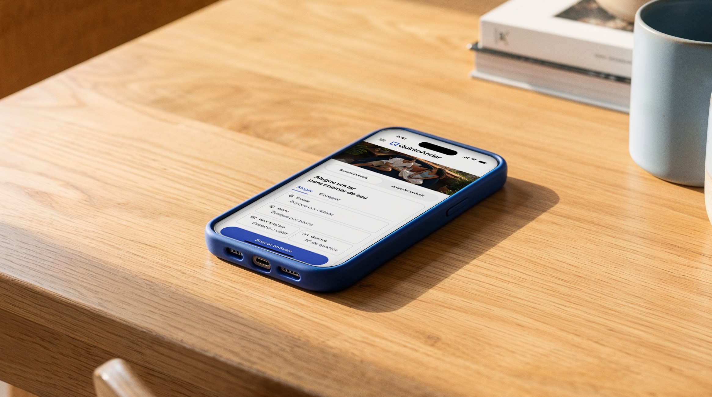 QuintoAndar property search displayed on a blue-cased smartphone on a wooden table