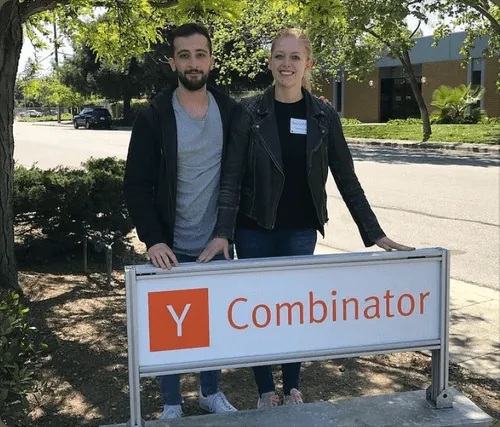 Mahyar Raissi and Daryna Kulya standing behind a Y Combinator sign