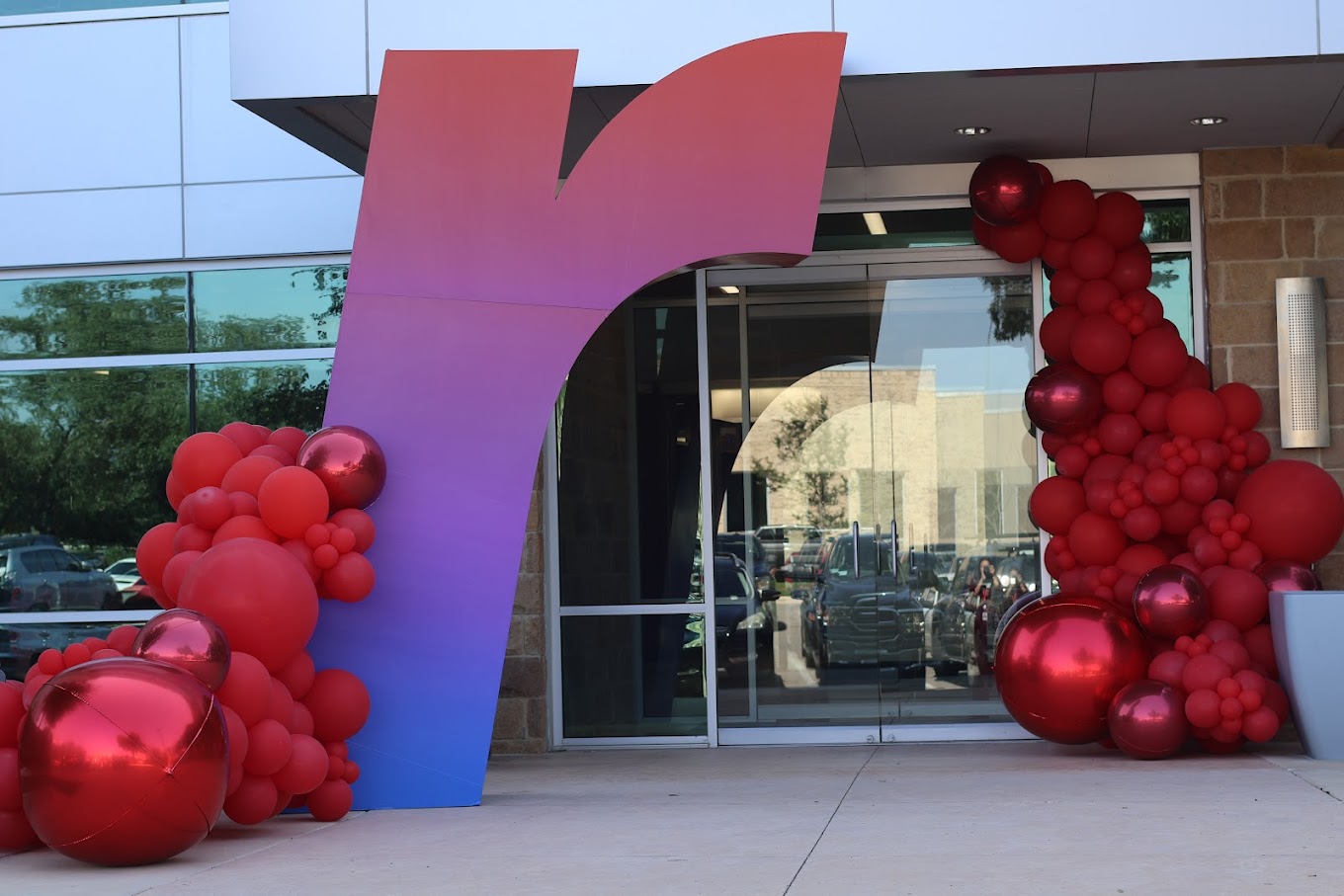 A large Rackspace symbol beside red balloons at an office entrance