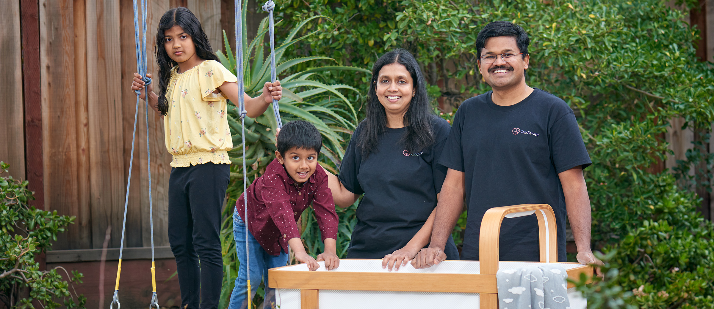 Radhika and Bharath Patil with their two children beside a Cradlewise crib