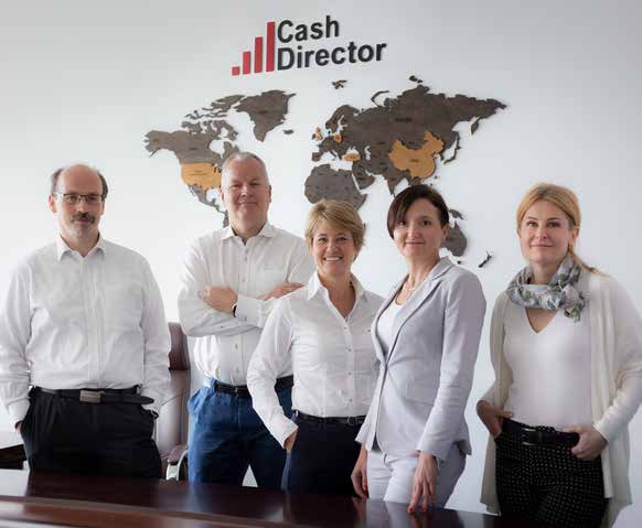 CashDirector colleagues standing together in an office beneath a world map